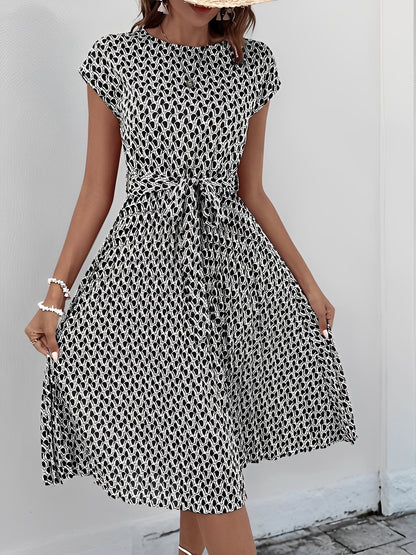 Black - Woman wearing a woven floral cap-sleeve midi dress with a self-tie waist and pleated skirt.