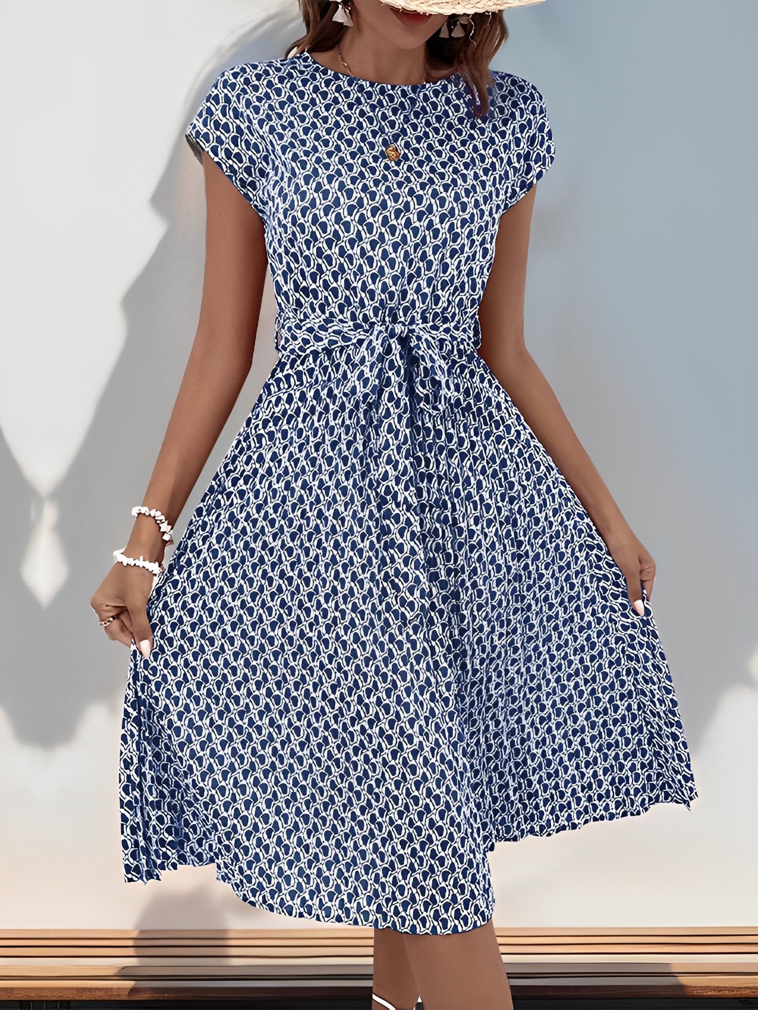 Navy Blue - Woman wearing a woven floral cap-sleeve midi dress with a self-tie waist and pleated skirt.