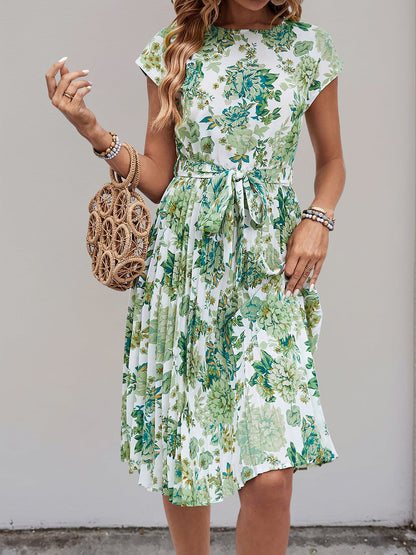 Green - Woman wearing a woven floral cap-sleeve midi dress with a self-tie waist and pleated skirt.
