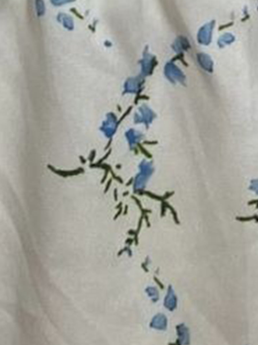 Blue - Woman wearing a woven floral square-neck midi dress with short puff sleeves and a shirred bodice