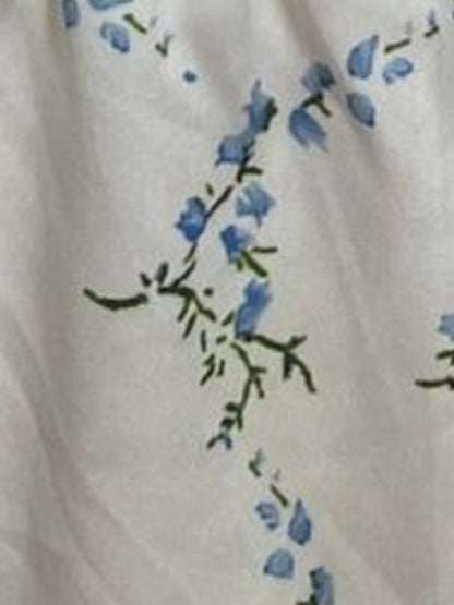 Blue - Woman wearing a woven floral square-neck midi dress with short puff sleeves and a shirred bodice