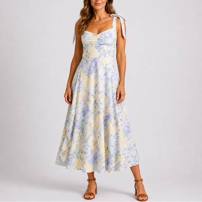 Floral White - Model wearing a woven floral midi dress featuring a sweetheart neckline, tie-shoulder straps, and a flowing A-line skirt.
