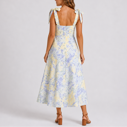 Floral White - Model wearing a woven floral midi dress featuring a sweetheart neckline, tie-shoulder straps, and a flowing A-line skirt.
