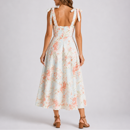 Floral White - Model wearing a woven floral midi dress featuring a sweetheart neckline, tie-shoulder straps, and a flowing A-line skirt.