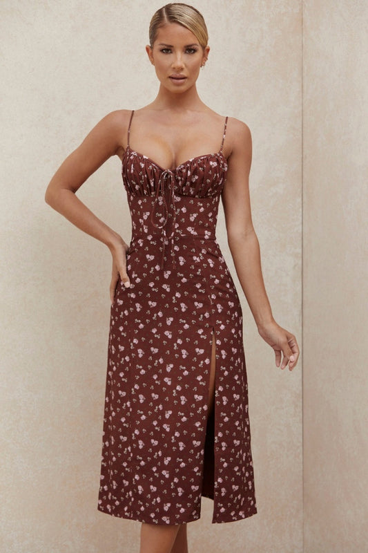 Women's brown midi dress featuring a ditsy floral print, ruched bust with tie detail, spaghetti straps, and a high thigh slit.