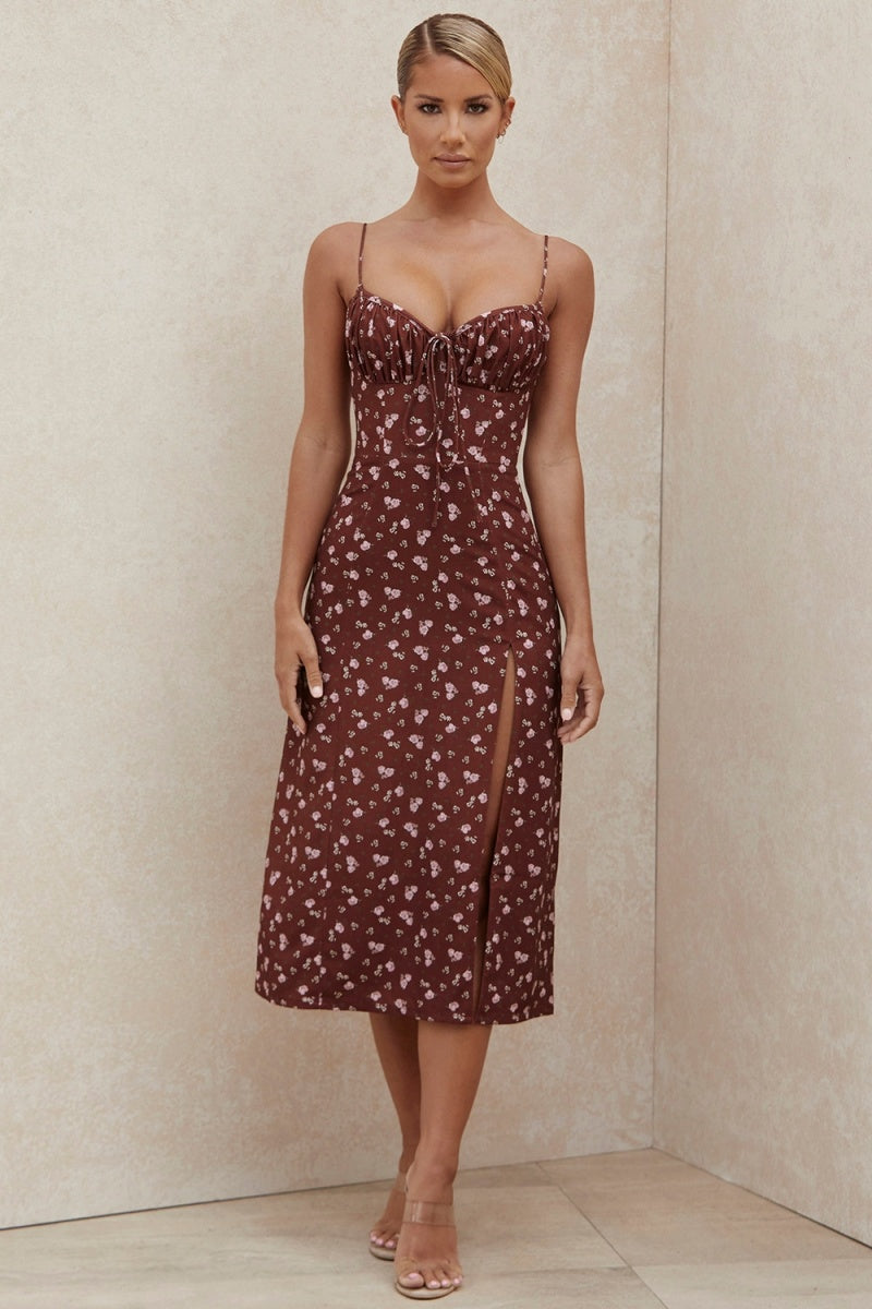 Women's brown midi dress featuring a ditsy floral print, ruched bust with tie detail, spaghetti straps, and a high thigh slit.