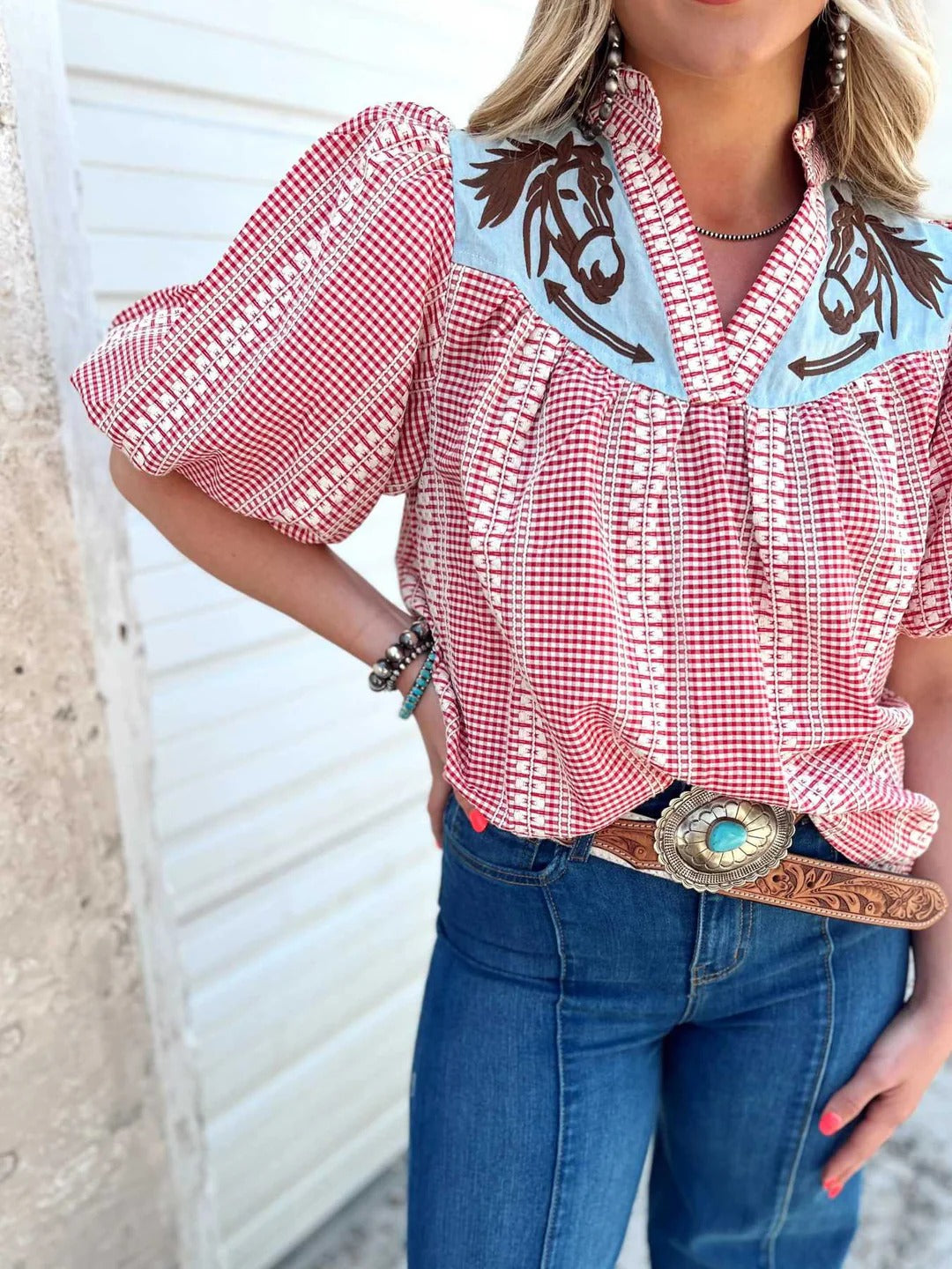 Red - Women's relaxed fit blouse in a red and white gingham pattern, featuring a contrasting light blue V-neck yoke with brown embroidered horse motifs and short puff sleeves.