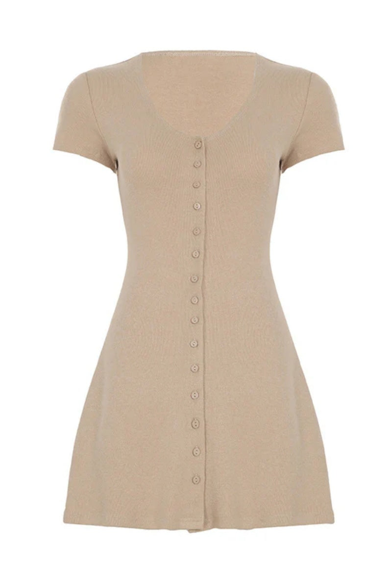 Beige - A woman wearing a fitted, textured beige mini dress with a button-down front, short sleeves, and a deep V-neckline, standing outdoors holding sunglasses and a woven bag.