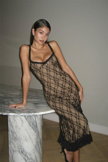 Black - A woman modelling a fitted midi dress featuring a black floral lace overlay over a nude lining, complete with ruffled straps, a corset-style bodice, and a frilled hem.