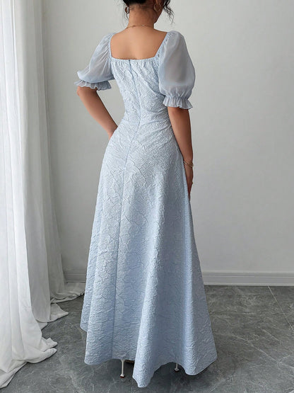 Grey Blue - Model wearing a textured jacquard A-line maxi dress with sheer puff sleeves and side lace-up bodice detailing.