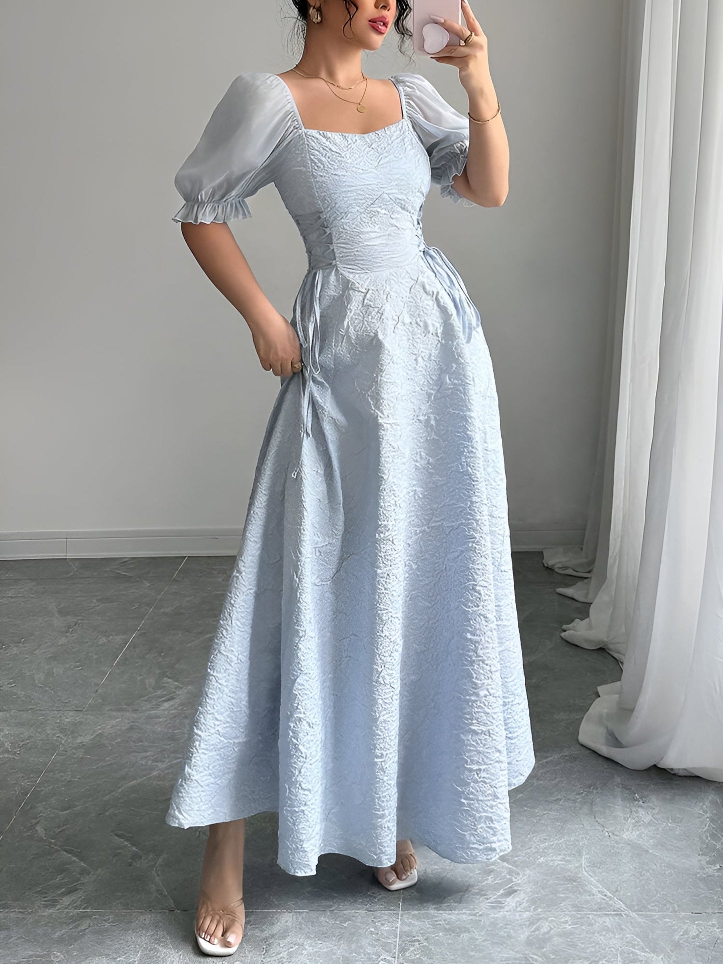 Grey Blue - Model wearing a textured jacquard A-line maxi dress with sheer puff sleeves and side lace-up bodice detailing.