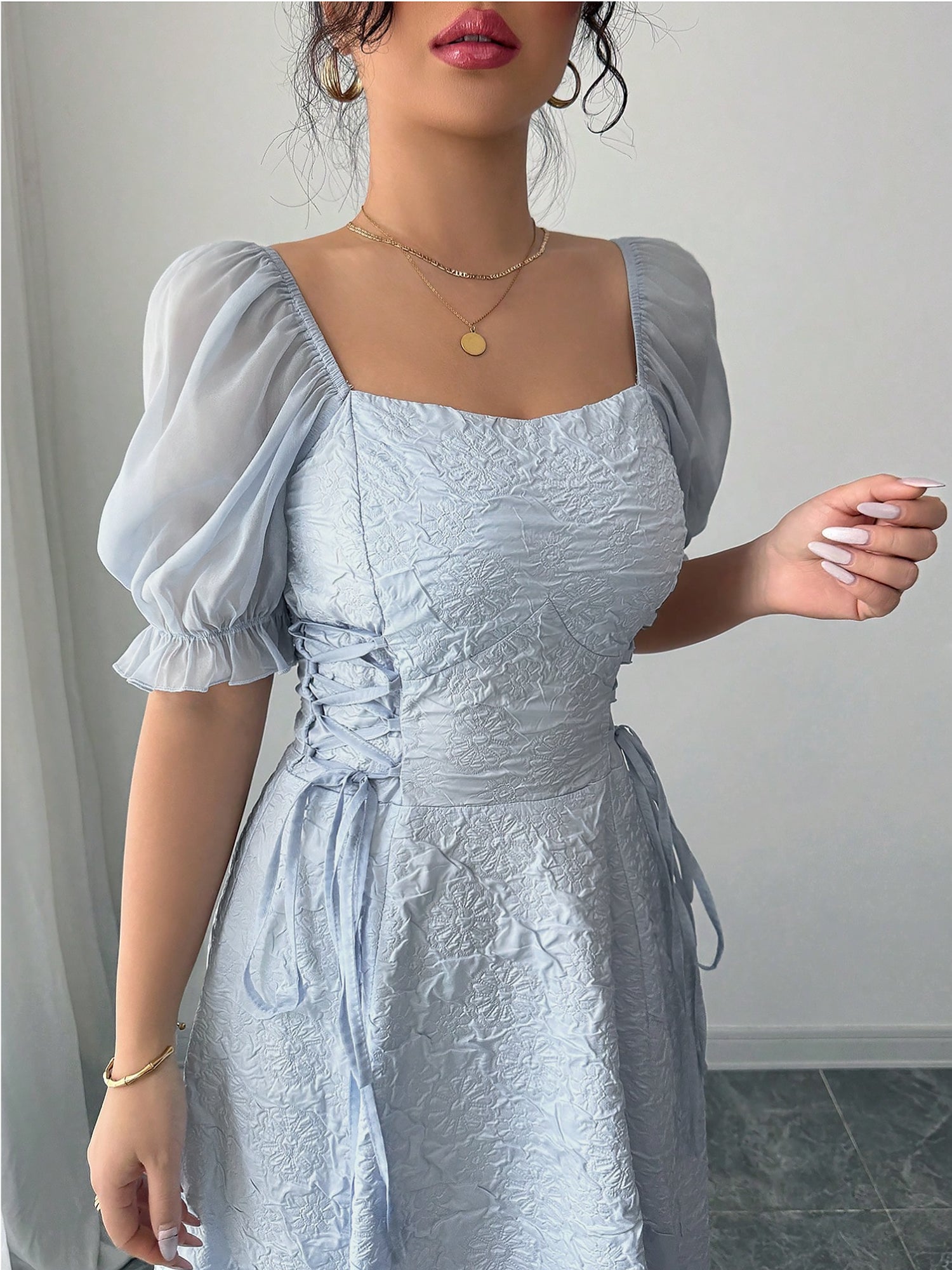 Grey Blue - Model wearing a textured jacquard A-line maxi dress with sheer puff sleeves and side lace-up bodice detailing.