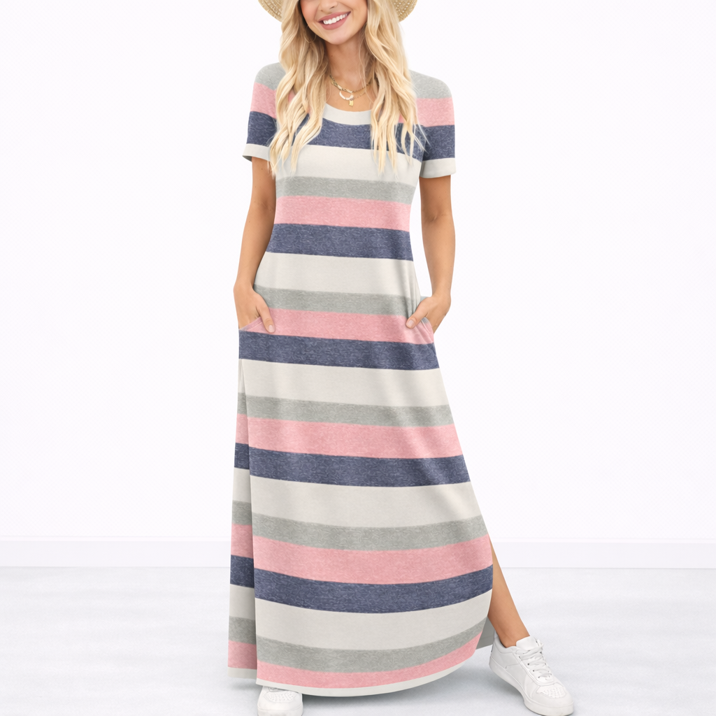 Striped Pink - Model wearing a striped short-sleeve maxi dress with a round neckline, side pockets, and a subtle side split, styled with trainers and a straw hat.
