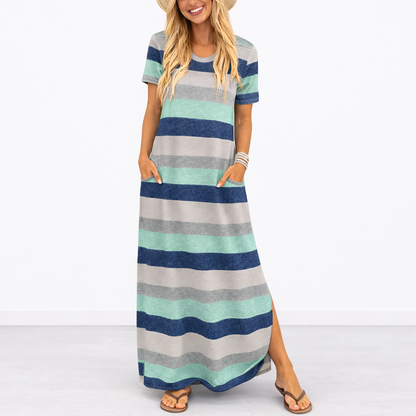 Striped Blue - Model wearing a striped short-sleeve maxi dress with a round neckline, side pockets, and a subtle side split, styled with trainers and a straw hat.