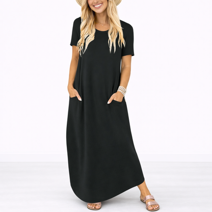Black - Model wearing a striped short-sleeve maxi dress with a round neckline, side pockets, and a subtle side split, styled with trainers and a straw hat.