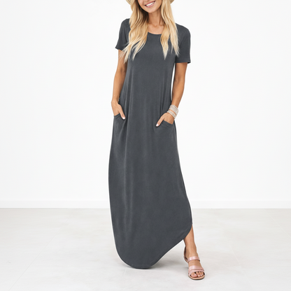 Grey - Model wearing a striped short-sleeve maxi dress with a round neckline, side pockets, and a subtle side split, styled with trainers and a straw hat.