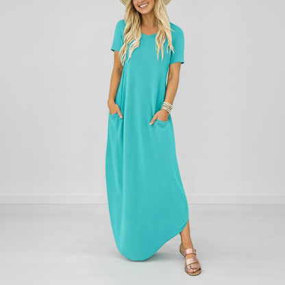 Light blue - Model wearing a striped short-sleeve maxi dress with a round neckline, side pockets, and a subtle side split, styled with trainers and a straw hat.