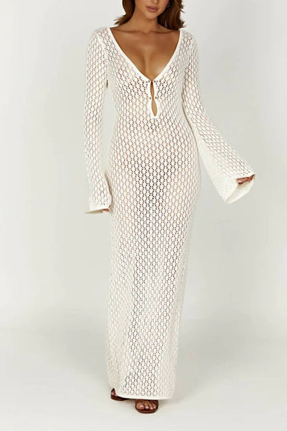 White - A woman wearing a white, semi-sheer crochet maxi dress with long flared sleeves and a deep V-neckline with keyhole detailing, standing outdoors.