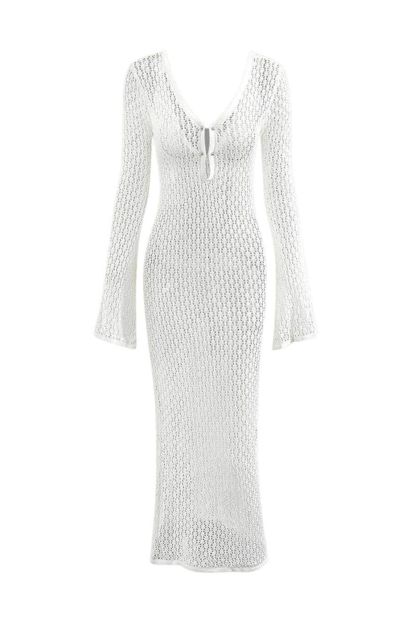 White - A woman wearing a white, semi-sheer crochet maxi dress with long flared sleeves and a deep V-neckline with keyhole detailing, standing outdoors.