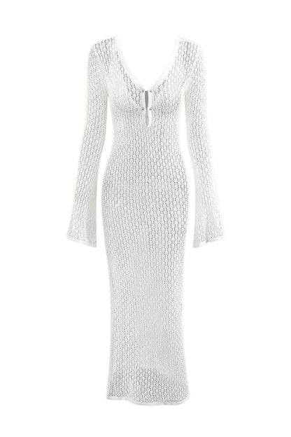 White - A woman wearing a white, semi-sheer crochet maxi dress with long flared sleeves and a deep V-neckline with keyhole detailing, standing outdoors.