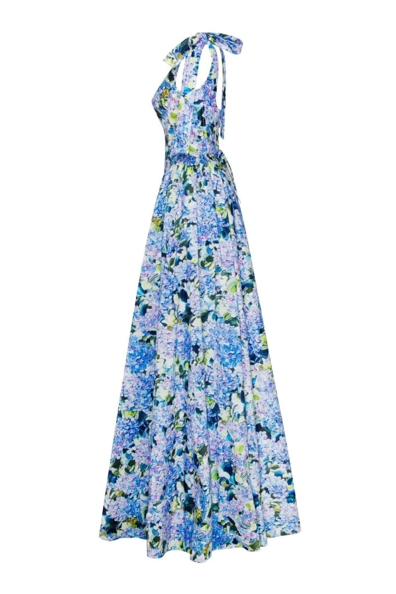 Blue - A woman models an elegant floor-length maxi dress featuring a structured corset bodice, tie-shoulder straps, and a vibrant blue and green floral print on a crisp, voluminous fabric.