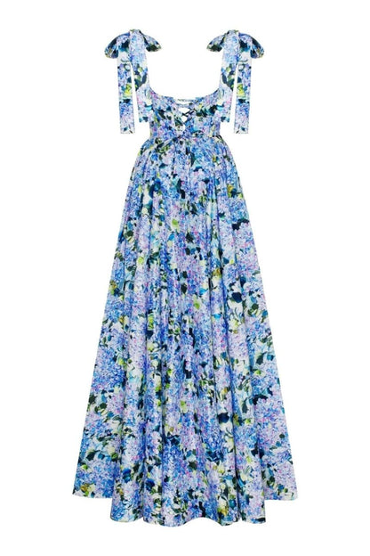 Blue - A woman models an elegant floor-length maxi dress featuring a structured corset bodice, tie-shoulder straps, and a vibrant blue and green floral print on a crisp, voluminous fabric.