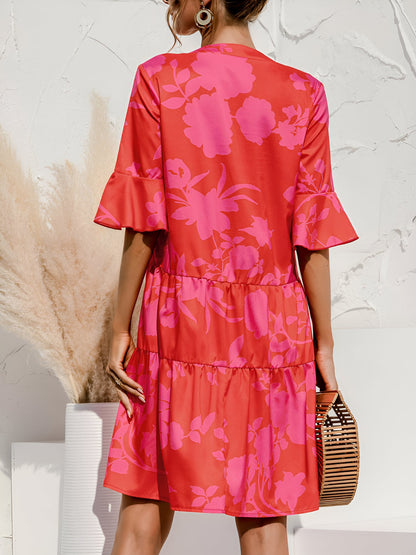 Rose Red - Model wearing a woven leopard print v-neck tiered mini dress with flutter sleeves and neckline tie details, holding a structured bamboo handbag.