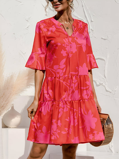 Rose Red - Model wearing a woven leopard print v-neck tiered mini dress with flutter sleeves and neckline tie details, holding a structured bamboo handbag.