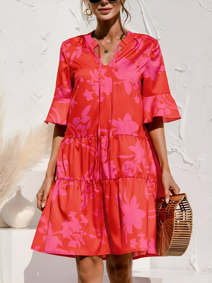 Rose Red - Model wearing a woven leopard print v-neck tiered mini dress with flutter sleeves and neckline tie details, holding a structured bamboo handbag.