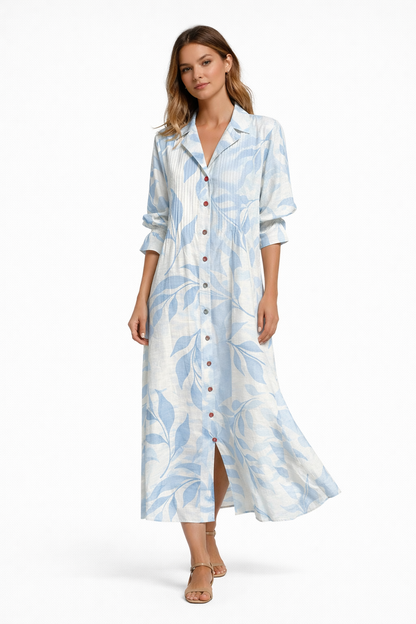 Light Blue Foral - Woman wearing a long, relaxed-fit botanical print shirt dress with 3/4 sleeves, a collared neckline, and button-down front.