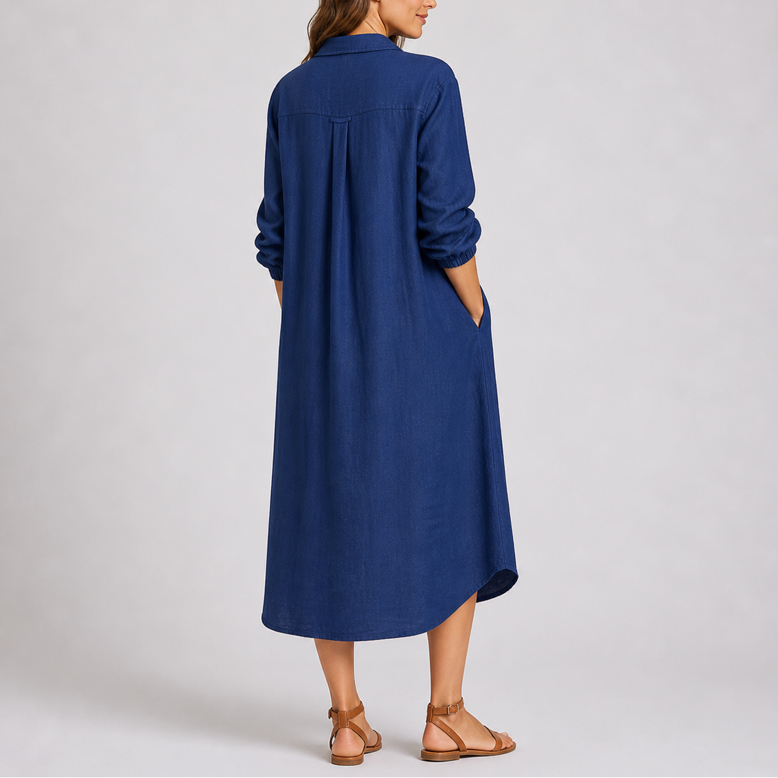 Blue - Woman modelling a relaxed fit, long-sleeve midi shirt dress featuring a collared neckline, button-down front, and side pockets.