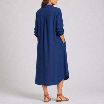 Blue - Woman modelling a relaxed fit, long-sleeve midi shirt dress featuring a collared neckline, button-down front, and side pockets.