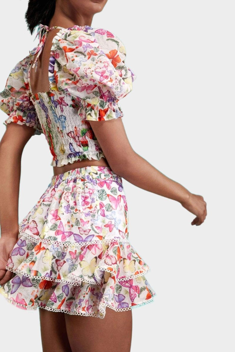White - Women's white cropped blouse featuring a colourful butterfly and botanical print, a shirred bodice, square neckline, and short puff sleeves, paired with a matching tiered mini skirt.