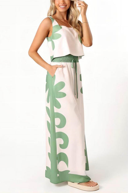 White - A woman wearing a white two-piece summer set featuring a cropped square-neck top and high-waisted wide-leg trousers, both adorned with a bold green abstract botanical print.