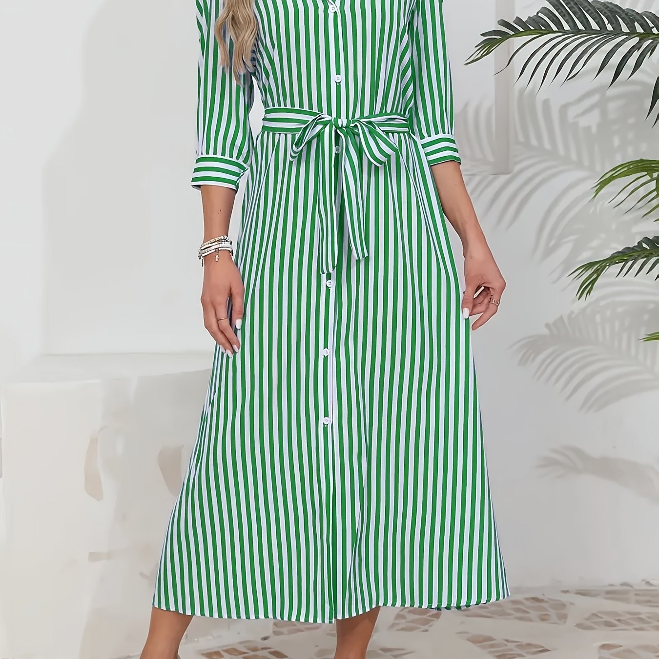 Green - Woman wearing a striped poplin midi shirt dress with 3/4 sleeves, a collared neckline, and a tie waist, styled with white trainers.