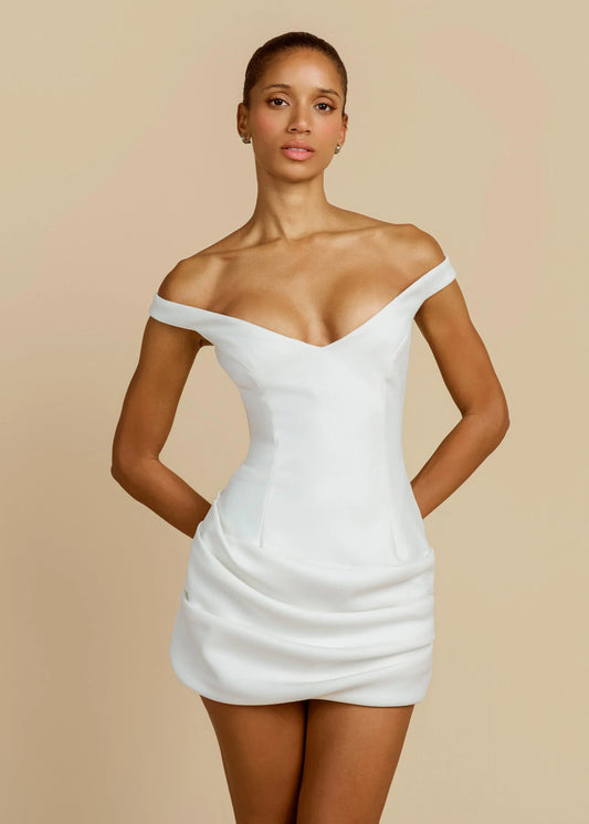 Women's white off-the-shoulder mini dress featuring a structured corset-style bodice with a plunging neckline and a draped, ruched skirt.