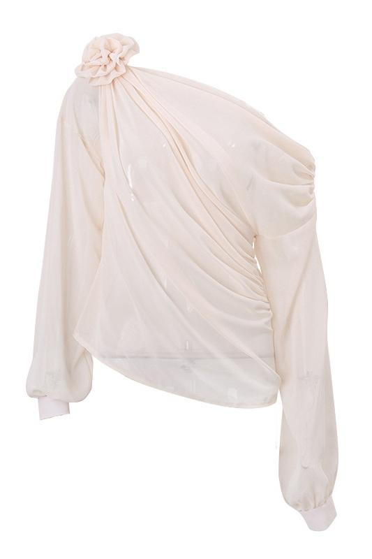 Beige - A woman wearing an elegant, cream-coloured, one-shoulder draped blouse featuring a large 3D floral appliqué on the right shoulder and a single long sleeve.