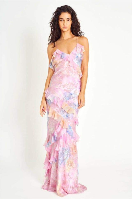 Pink - A woman walking outdoors wearing a flowing, pastel floral maxi dress featuring cascading ruffles and delicate spaghetti straps.