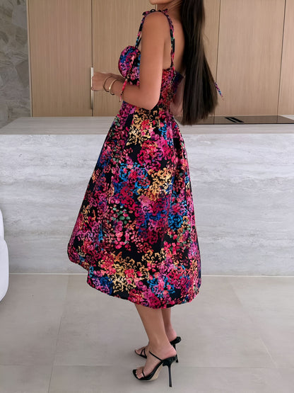 Black - Woman modelling a printed A-line midi dress featuring a sweetheart neckline, button-down bodice, and adjustable tie-straps.