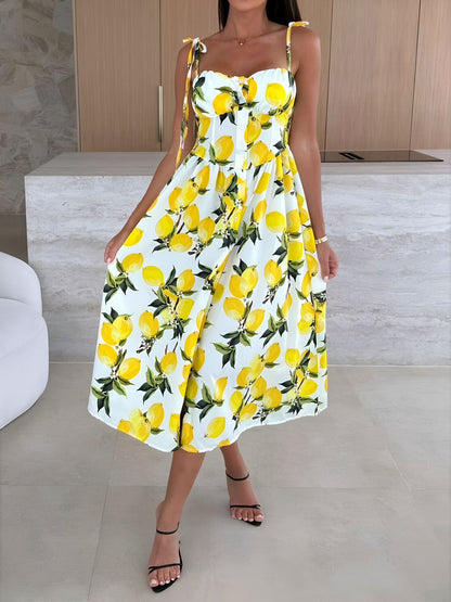 Yellow - Woman modelling a printed A-line midi dress featuring a sweetheart neckline, button-down bodice, and adjustable tie-straps.