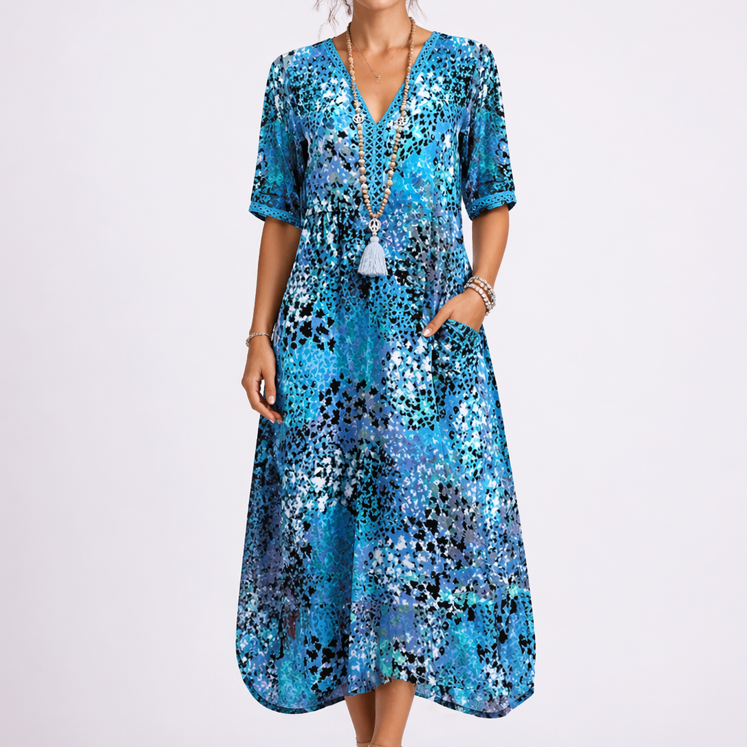 Blue - Model wearing a woven abstract-print V-neck relaxed midi dress with short sleeves and side pockets