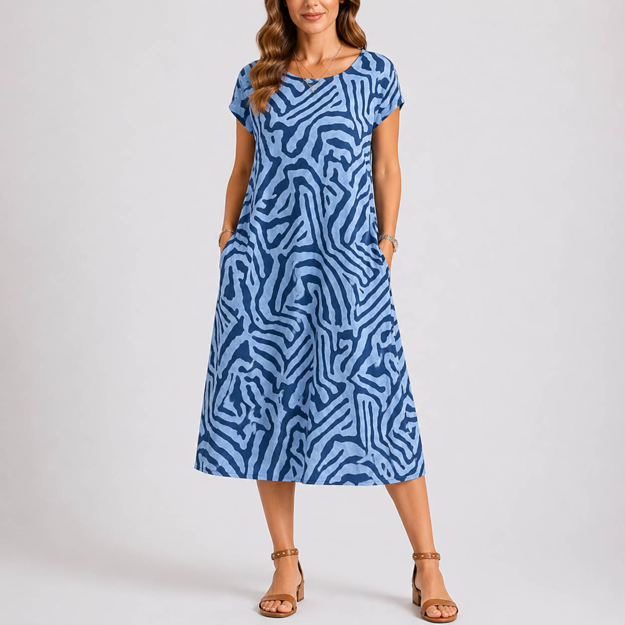 Blue - Woman wearing a woven abstract patterned short-sleeve midi dress with side pockets.