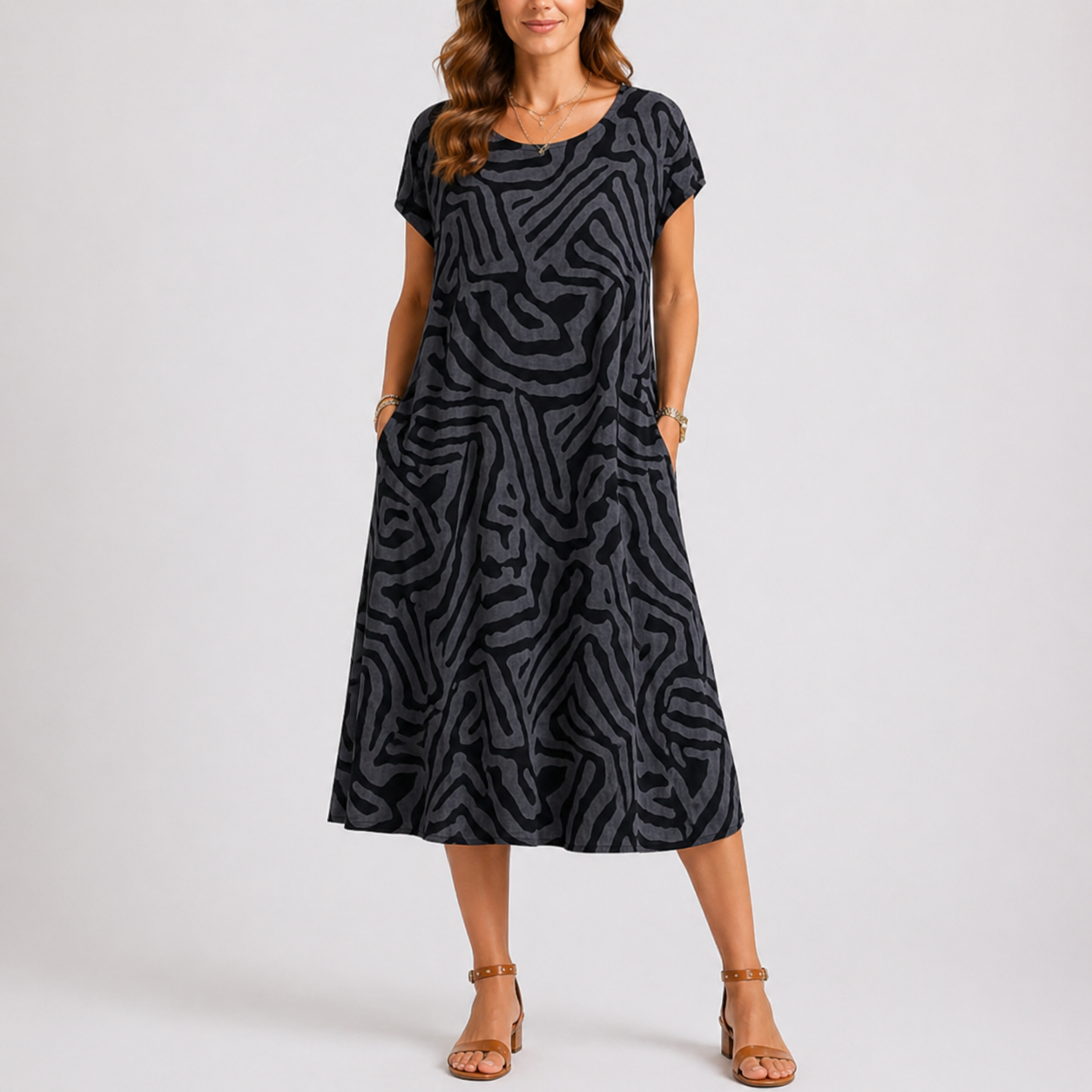 Black - Woman wearing a woven abstract patterned short-sleeve midi dress with side pockets.