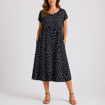 Black - Woman wearing a woven abstract patterned short-sleeve midi dress with side pockets.