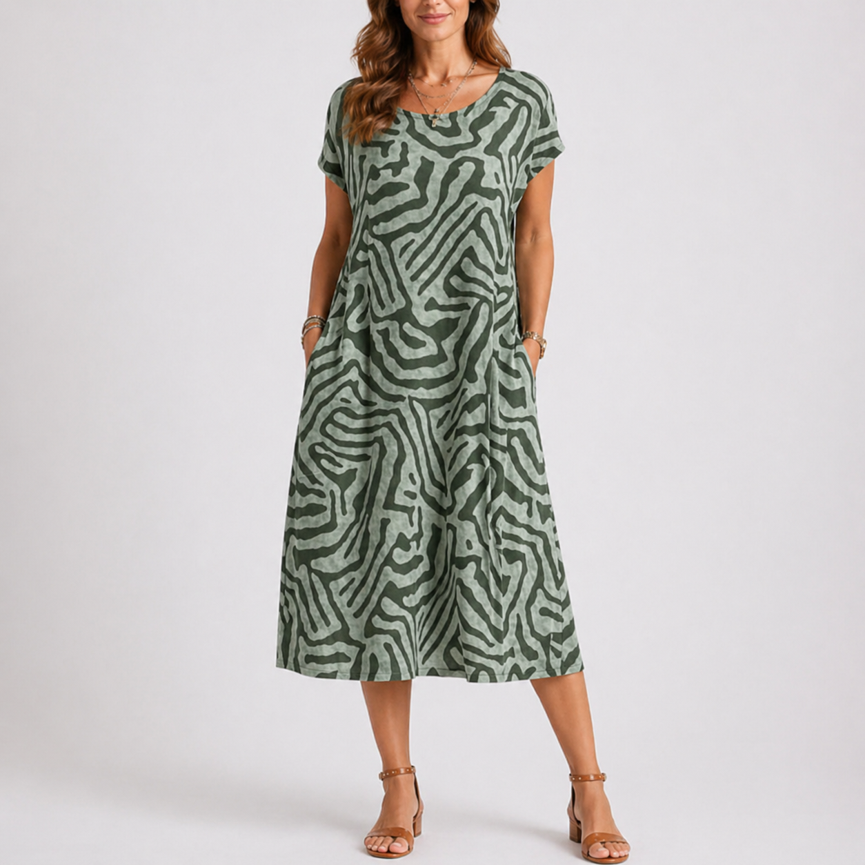 Green - Woman wearing a woven abstract patterned short-sleeve midi dress with side pockets.