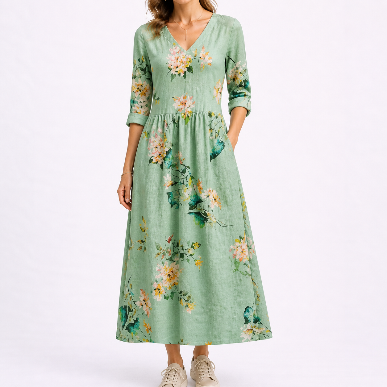Green - Woman wearing a woven floral midaxi dress with a V-neckline, 3/4-sleeves, and a gathered waist with side pockets, styled with trainers.