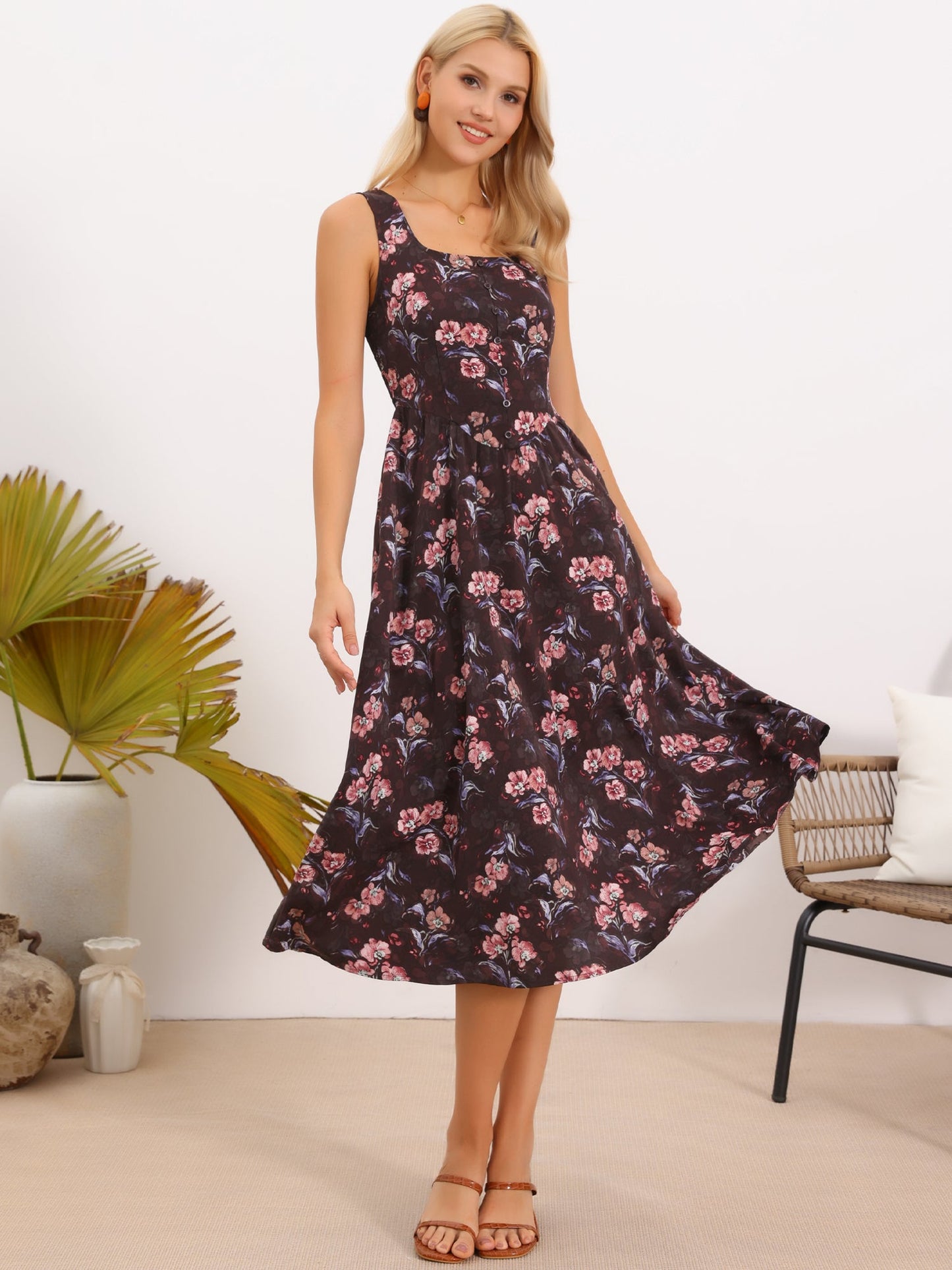 Brown Red Floral - Model wearing a sleeveless floral A-line midi dress with a square neckline and front button detailing, posing in a bright studio setting.