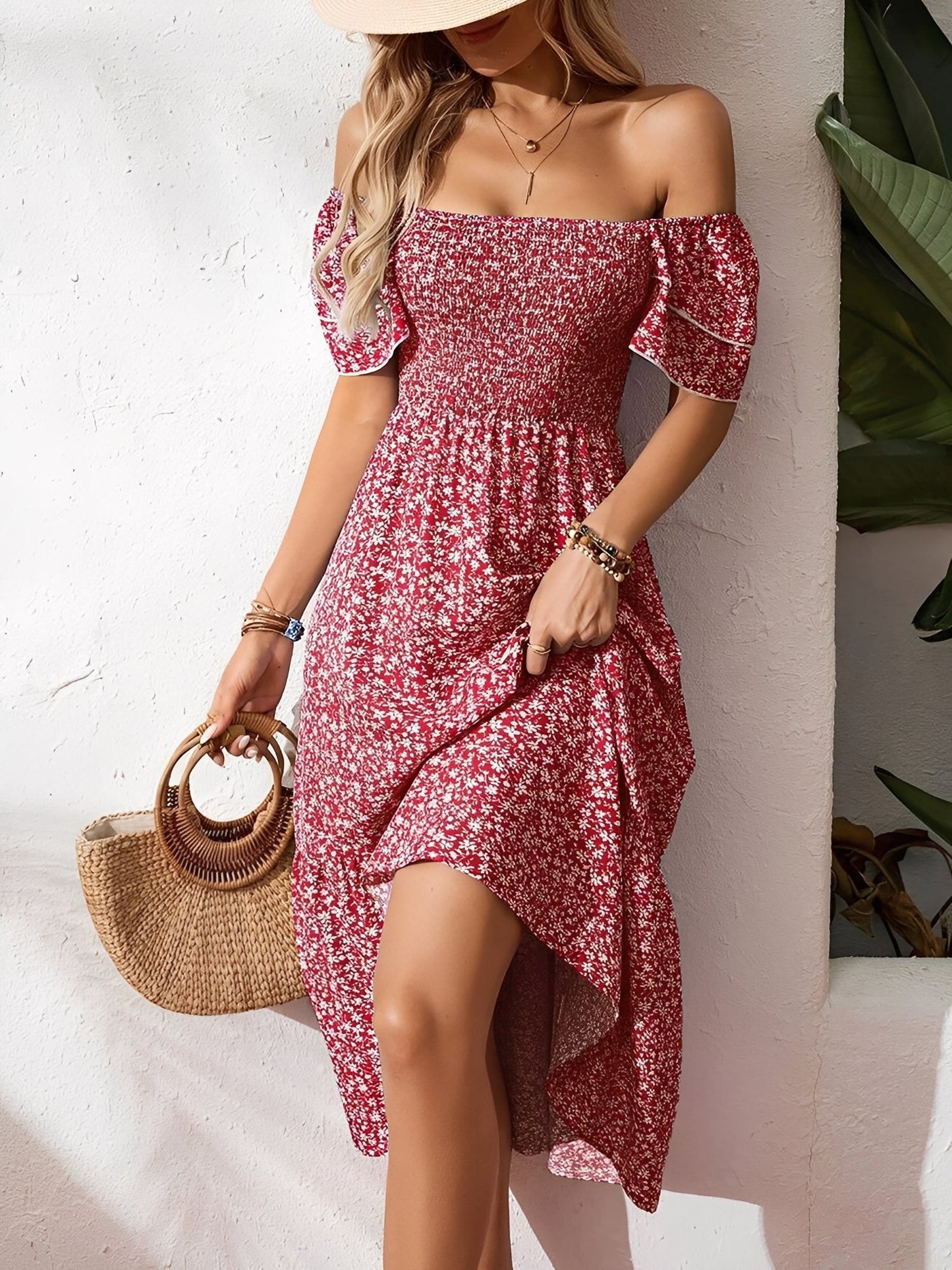Red - Woman wearing a woven floral square-neck midi dress with a smocked bodice, flutter sleeves, and a tiered skirt, styled with a straw hat and woven bag.