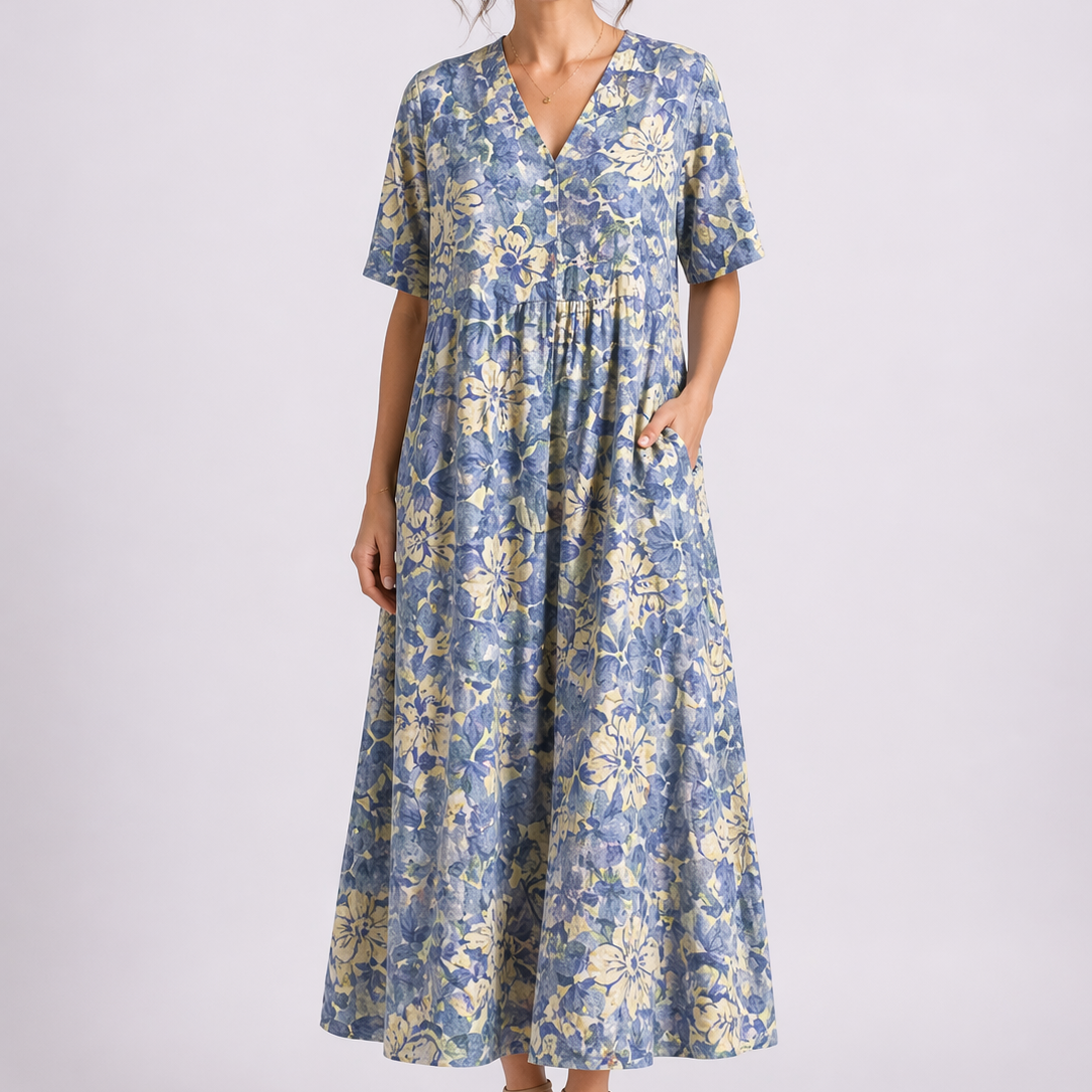 Blue - Woman wearing a woven floral V-neck maxi dress with short sleeves and side pockets.