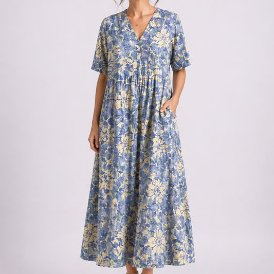 Blue - Woman wearing a woven floral V-neck maxi dress with short sleeves and side pockets.